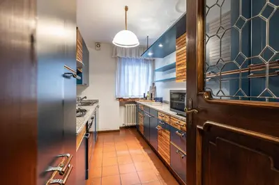 a kitchen with blue walls and a wooden door at Casa Cavallino, in centro a Cortina dAmpezzo in Cortina dʼAmpezzo