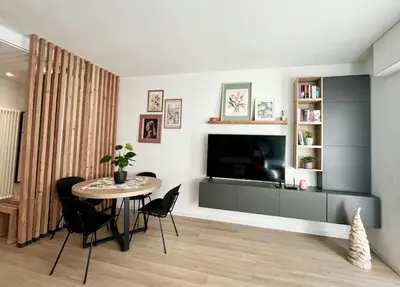 a living room with a table and a television at The Cozy Peak - 360 Dolomites View in Agordo