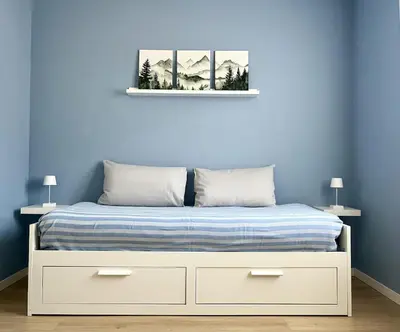 a bedroom with a bed with a blue wall at The Cozy Peak - 360 Dolomites View in Agordo