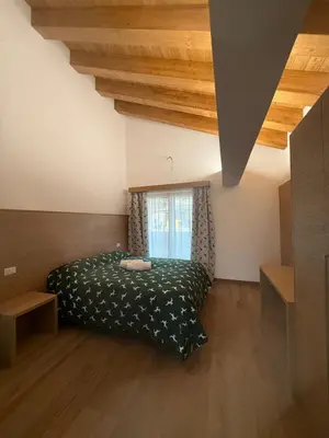 a bedroom with a bed and a window at Locanda Baita Donariè in San Vito di Cadore