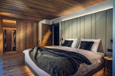 a bedroom with a large bed and wooden walls at Sorafurcia Lodge in Sorafurcia