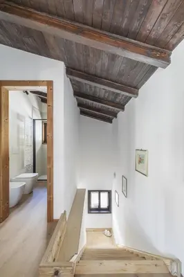 a bathroom with a wooden ceiling and a staircase at Ciasa Remo 2 by WelcHome in San Vito di Cadore