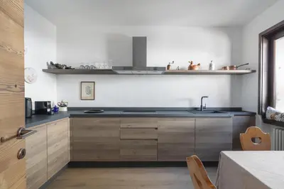 a kitchen with wooden cabinets and a sink at Ciasa Remo 2 by WelcHome in San Vito di Cadore