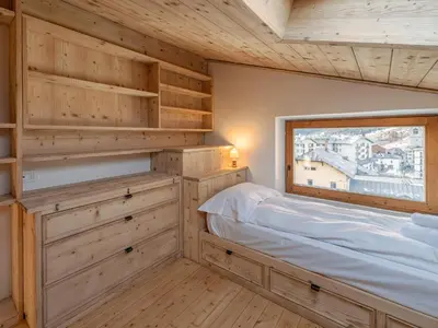a bedroom with a bed and a window at Casa Poligrafica 2, panoramica e super confortevole in Cortina dʼAmpezzo