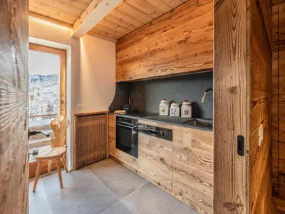 a kitchen with a stove and a sink at Casa Poligrafica 2, panoramica e super confortevole in Cortina dʼAmpezzo