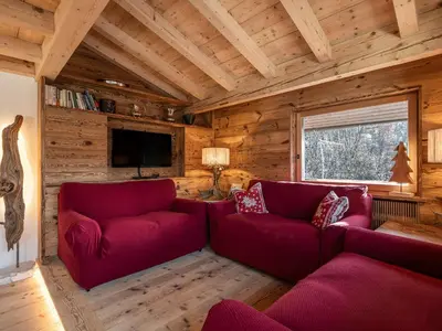 a living room with red couches in a log cabin at Casa Poligrafica 2, panoramica e super confortevole in Cortina dʼAmpezzo