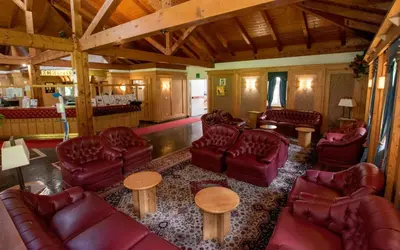 a living room with leather couches and tables at Villaggio Ploner in Dobbiaco