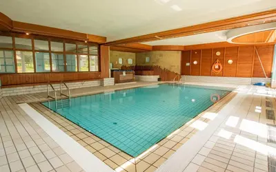 a large swimming pool in a large building at Villaggio Ploner in Dobbiaco