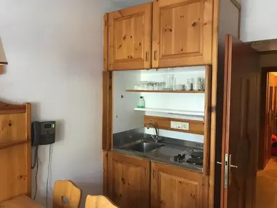 a kitchen with wooden cabinets and a sink at Villaggio Ploner in Dobbiaco