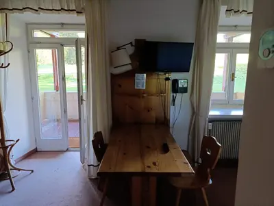 a room with a wooden table with a television on it at Villaggio Ploner in Dobbiaco
