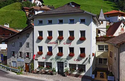 a white building with flowers on the side of it at Gasthof Greif in Sarntal