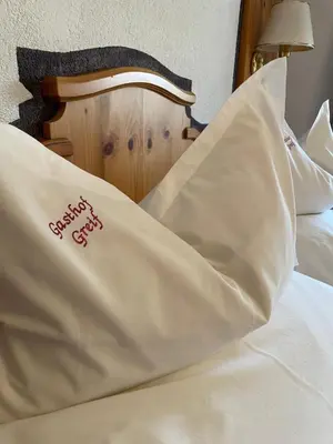 a bed with a pillow with the words naughty elf on it at Gasthof Greif in Sarntal