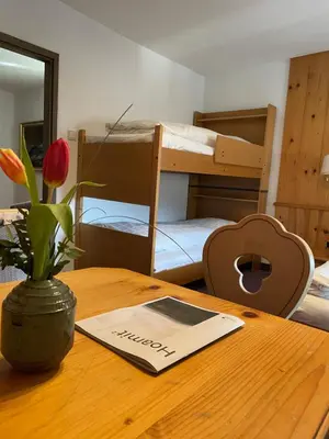 a room with a table with a vase with a flower on it at Gasthof Greif in Sarntal