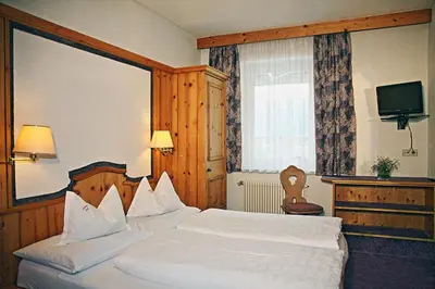 a hotel room with two beds and a television at Gasthof Greif in Sarntal