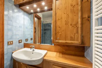 a bathroom with a sink and a mirror at Cozy 3 bedroom with beautiful view and access to garden in Cortina dʼAmpezzo