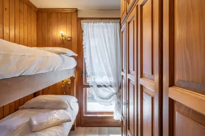 a bedroom with two bunk beds and a window at Cozy 3 bedroom with beautiful view and access to garden in Cortina dʼAmpezzo