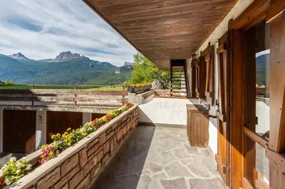 a porch of a house with a view of mountains at Cozy 3 bedroom with beautiful view and access to garden in Cortina dʼAmpezzo