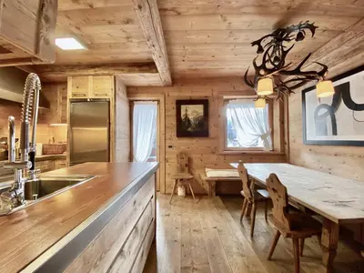a kitchen and dining room with a table in a cabin at Luxury flat with views - few steps from centre in Cortina dʼAmpezzo