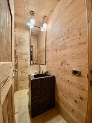 a wooden bathroom with a sink and a mirror at Luxury flat with views - few steps from centre in Cortina dʼAmpezzo