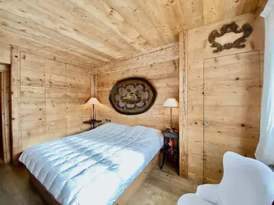 a bedroom with a bed in a wooden wall at Luxury flat with views - few steps from centre in Cortina dʼAmpezzo