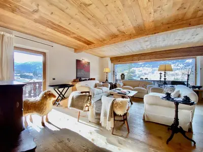 a living room filled with furniture and a wooden ceiling at Luxury flat with views - few steps from centre in Cortina dʼAmpezzo