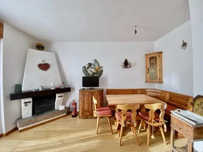 a living room with a wooden table and chairs at Cozy 3 bedroom in amazing location in Cortina dʼAmpezzo