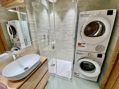 a bathroom with a washing machine and a sink at Cozy 3 bedroom in amazing location in Cortina dʼAmpezzo