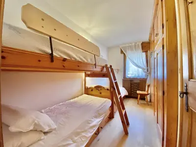 a bedroom with two bunk beds with a ladder at Cozy 3 bedroom in amazing location in Cortina dʼAmpezzo