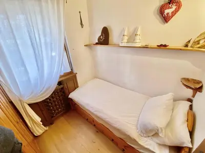 a small bed in a room with a window at Cozy 3 bedroom in amazing location in Cortina dʼAmpezzo