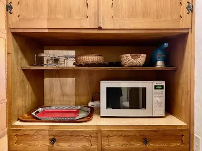 a microwave oven sitting on a wooden cabinet at Cozy 3 bedroom with beautiful views in Cortina dʼAmpezzo