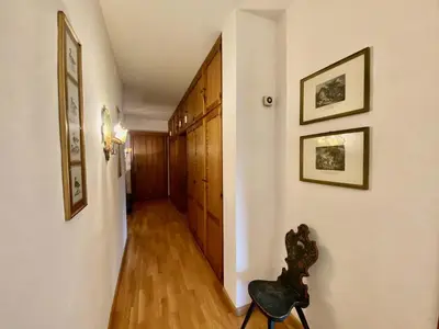a hallway with wood floors and white walls and a hallway with wooden cabinets at Cozy 3 bedroom with beautiful views in Cortina dʼAmpezzo