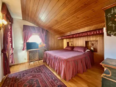 a bedroom with a bed and a wooden ceiling at Cozy 3 bedroom with beautiful views in Cortina dʼAmpezzo