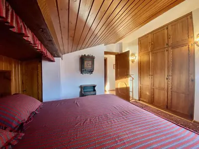 a bedroom with a large bed and a wooden ceiling at Cozy 3 bedroom with beautiful views in Cortina dʼAmpezzo