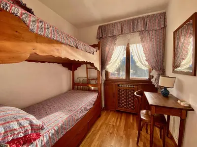 a bedroom with a bunk bed and a desk with a desk at Cozy 3 bedroom with beautiful views in Cortina dʼAmpezzo