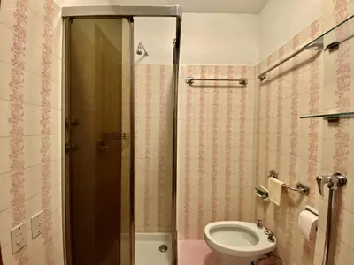 a bathroom with a toilet and a glass shower at Cozy 3 bedroom with beautiful views in Cortina dʼAmpezzo