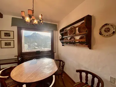a dining room with a table and chairs and a window at Cozy 3 bedroom with beautiful views in Cortina dʼAmpezzo