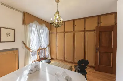 a dining room with a table and a window at Casa Coccola, panoramica e immersa nel verde in Cortina dʼAmpezzo