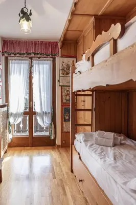 a bedroom with a bunk bed and a large window at Casa Coccola, panoramica e immersa nel verde in Cortina dʼAmpezzo