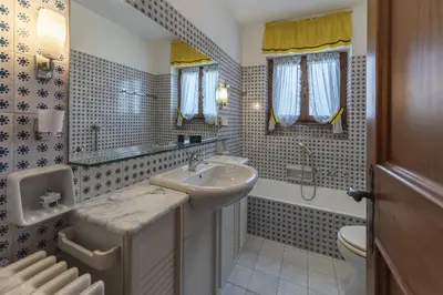 a bathroom with a sink and a shower and a toilet at Casa Coccola, panoramica e immersa nel verde in Cortina dʼAmpezzo