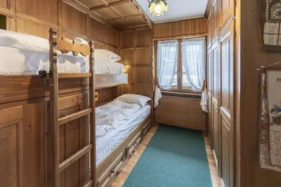 a room with two bunk beds and a window at Casa Coccola, panoramica e immersa nel verde in Cortina dʼAmpezzo