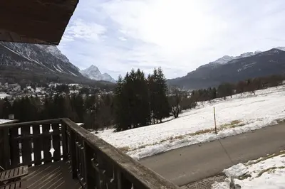 a balcony with a view of a snow covered mountain at Casa Coccola, panoramica e immersa nel verde in Cortina dʼAmpezzo