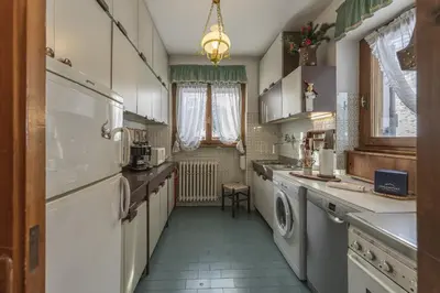 a kitchen with a washer and dryer in it at Casa Coccola, panoramica e immersa nel verde in Cortina dʼAmpezzo