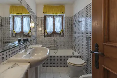 a bathroom with a sink and a toilet and a tub at Casa Coccola, panoramica e immersa nel verde in Cortina dʼAmpezzo
