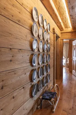 a wall of plates on a wooden wall at Casa Merisanda, confortevole e immersa nel verde in Cortina dʼAmpezzo