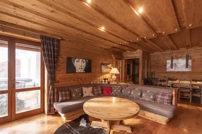 a living room with a couch and a table at Casa Merisanda, confortevole e immersa nel verde in Cortina dʼAmpezzo