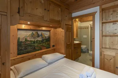 a bedroom with wooden walls and a bed in a room at Casa Col 3, graziosa e confortevole a due passi dalle piste in Cortina dʼAmpezzo
