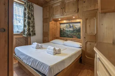 a bedroom with a bed with towels on it at Casa Col 3, graziosa e confortevole a due passi dalle piste in Cortina dʼAmpezzo