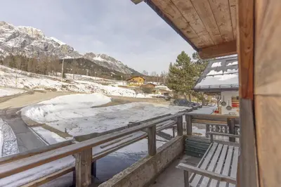a balcony with a bench and a snow covered mountain at Casa Col 3, graziosa e confortevole a due passi dalle piste in Cortina dʼAmpezzo