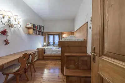 a bedroom with a bed and a desk and a table at Casa Varentin, in the center of Cortina in Cortina dʼAmpezzo