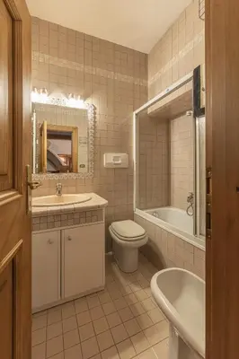 a bathroom with a sink and a toilet and a tub at Casa Varentin, in the center of Cortina in Cortina dʼAmpezzo